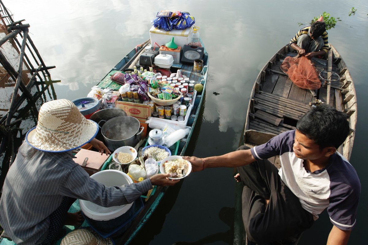 阪口 克 Pa Twitter 写真展用写真セレクト中 カンボジアトンレサップ湖から 水上集落に住む漁師さんの昼ごはん 集落に は色々な水上売店が巡回している 八百屋船や雑貨屋船 充電船に床屋船など様々だが さすがに魚屋船はない 笑 今日の昼飯は八百屋船特性の汁