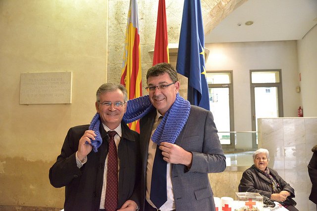 La web de <a href="/cortsval/">Corts Valencianes</a> es fa ressò de de l'acció solidària de les #innovafalles amb esta foto. <a href="/enricmorera/">Enric Morera</a> dona la bufanda a <a href="/CruzRojaCV/">Cruz Roja en Comunidad Valenciana</a>