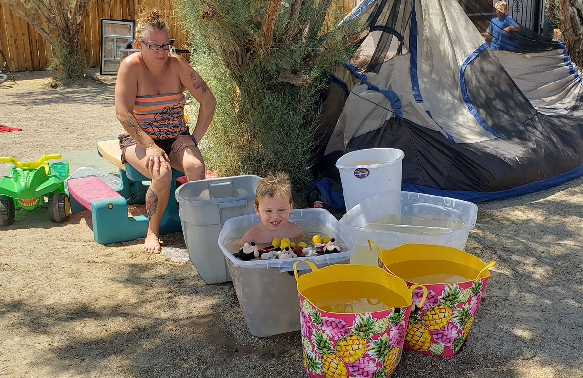 DoualyX's tweet photo. Jessica Schultz of Trona and three-year-old Jakob take advantage of a water truck that filled their tubs. They still have no running water. Electricity is on. Tonight, they plan to sleep in their tent. #californiaearthquake/ #Afterquake https://t.co/XTXQ5MxVvr