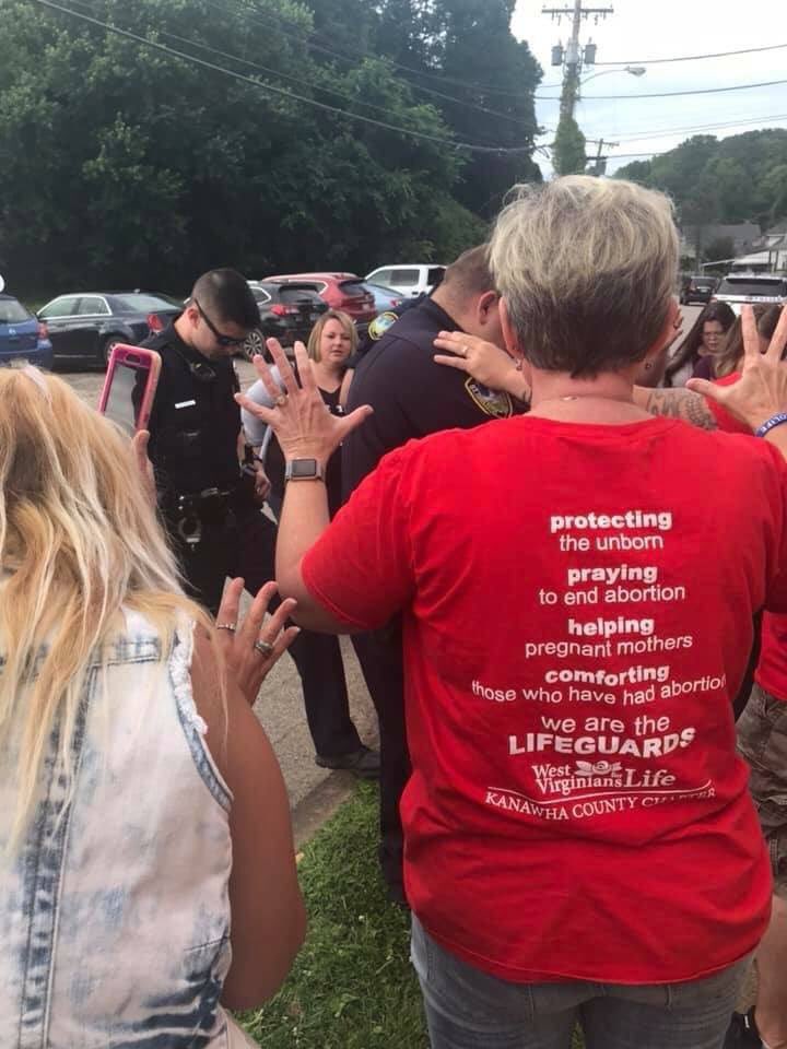 WestVirginiaIWW's tweet photo. Nothing special today. Just members of the @CharlestonPDWV praying alongside anti-choice protesters to support the closing of the state’s last abortion clinic. https://t.co/8EtpS9fUqD