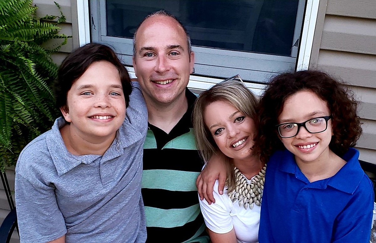 Michael, Anna, Jackson, & Henry Corbin with their arms wrapped around each other, smiling.