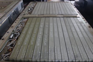 Inside the Apollo Guidance Computer. The computer contains rows of modules. Interface modules and logic modules are visible. At the left, the power supplies are tangles of circuitry.