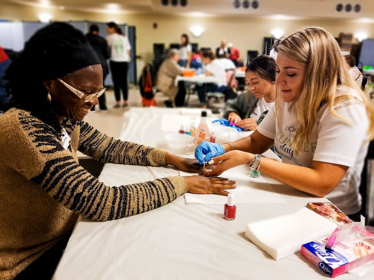 Senior getting nails done by L'oreal volunteer