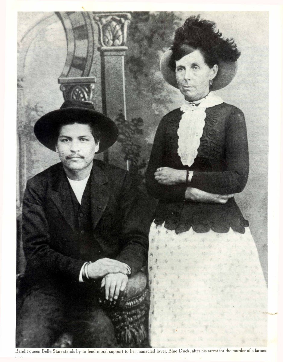 TracesofTexas's tweet photo. Infamous bandit queen Belle Starr, who spent quite a bit of time in Texas during her short life, and her lover Blue Duck, who had been arrested for murdering a farmer. It was taken on May 24, 1886. Note the handcuffs on Blue Duck's wrists. https://t.co/y3PILvR6Ym