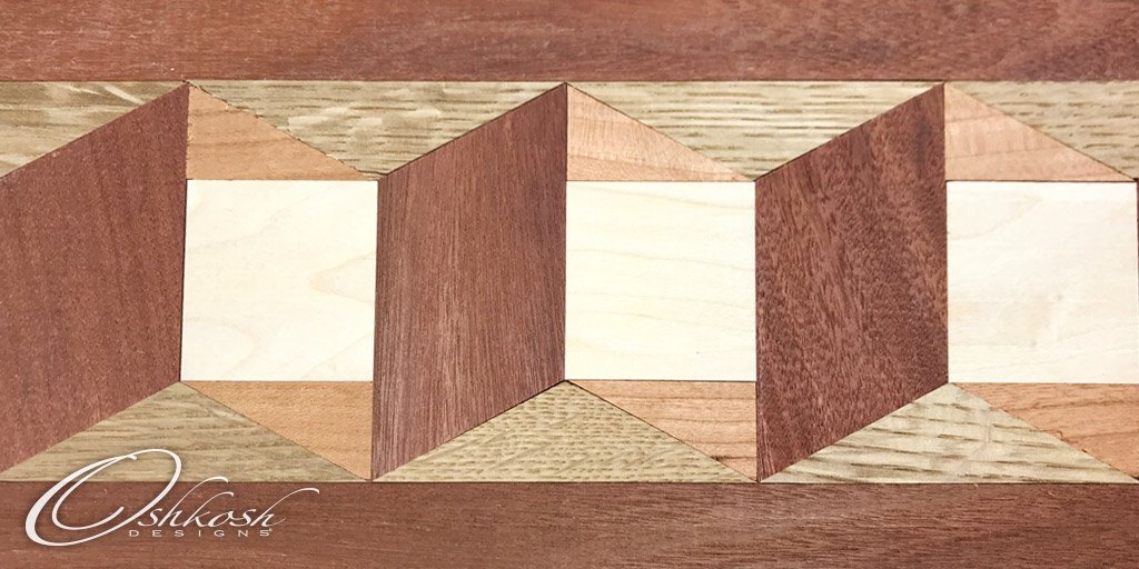 A traditional wood border, reminiscent of quilting patterns, shown in American cherry, maple, quarter-sawn white oak, and Santos mahogany. 

Have an idea? Contact us for a customized quote. bit.ly/2KIlmSq