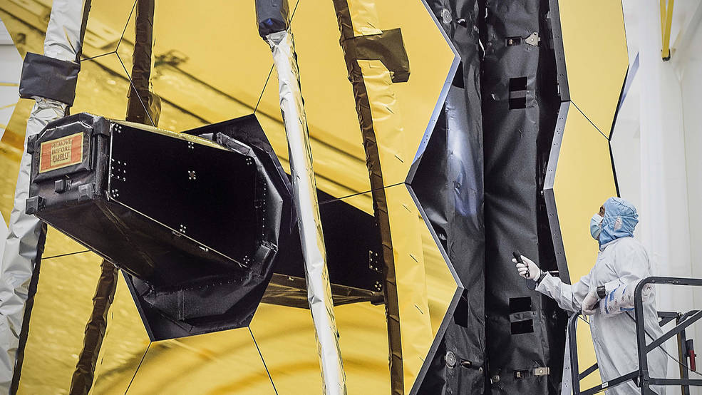 An engineer works on the James Webb Space Telescope mirror in a cleanroom