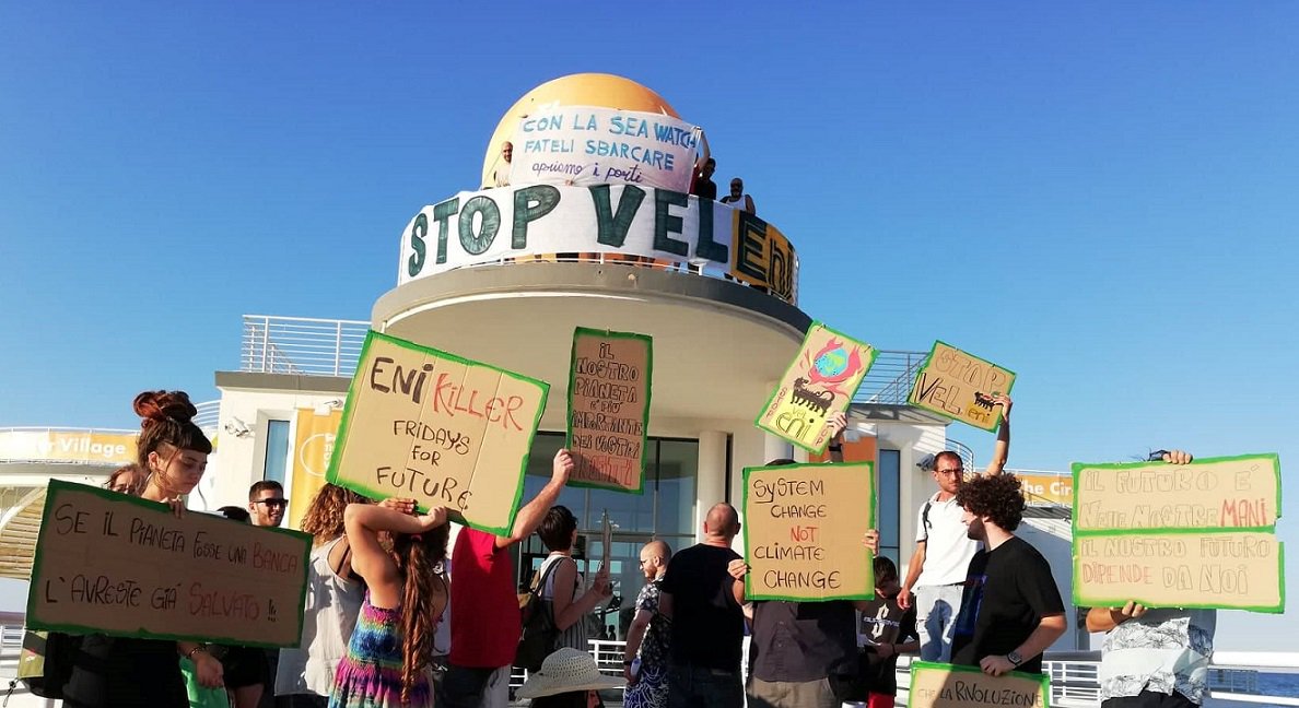 global_project's tweet photo. "Stop Vel-Eni, basta greenwashing" Occupato il villaggio Eni al CaterRaduno di Senigallia (An). Le/i manifestanti solidali con @SeaWatchItaly https://t.co/PSDuJBeaxq #StopEni #ClimateJustice #SocialJustice #FreeCarola https://t.co/X2bw4yEmQF