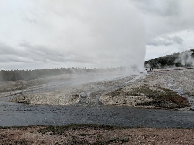 Eruption of Beehive geyser in the Upper Geyser Basin, with the Firehole River in the foreground.