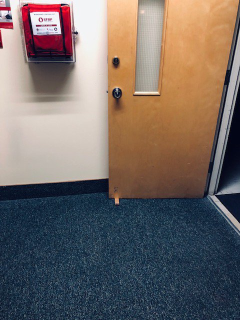 ThomasVail15's tweet photo. Went through my school and found out that Judith Gap schools loves their door wedges!!  School looked reasonably OK on fire violations from video and readings.  Check out the 4th of July theme of the blocked door.  Extinguishers in school were all certified last week.  #EDLD657 https://t.co/aNuHI127u7