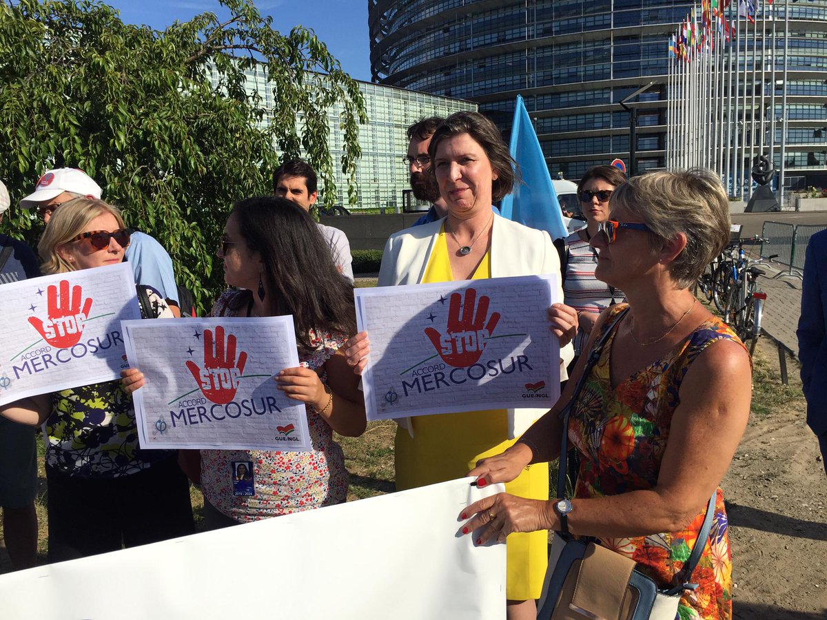 Left_EU's tweet photo. MEPs join protest outside the European Parliament denouncing the conclusion of the EU free trade agreement with Mercosur countries. 

We say a firm NO to the destruction of the environment, to GMOs and the legitimation of Bolsonaro´s far right government. 

#EUMercosur #EPlenary https://t.co/kvyLhYKXwV