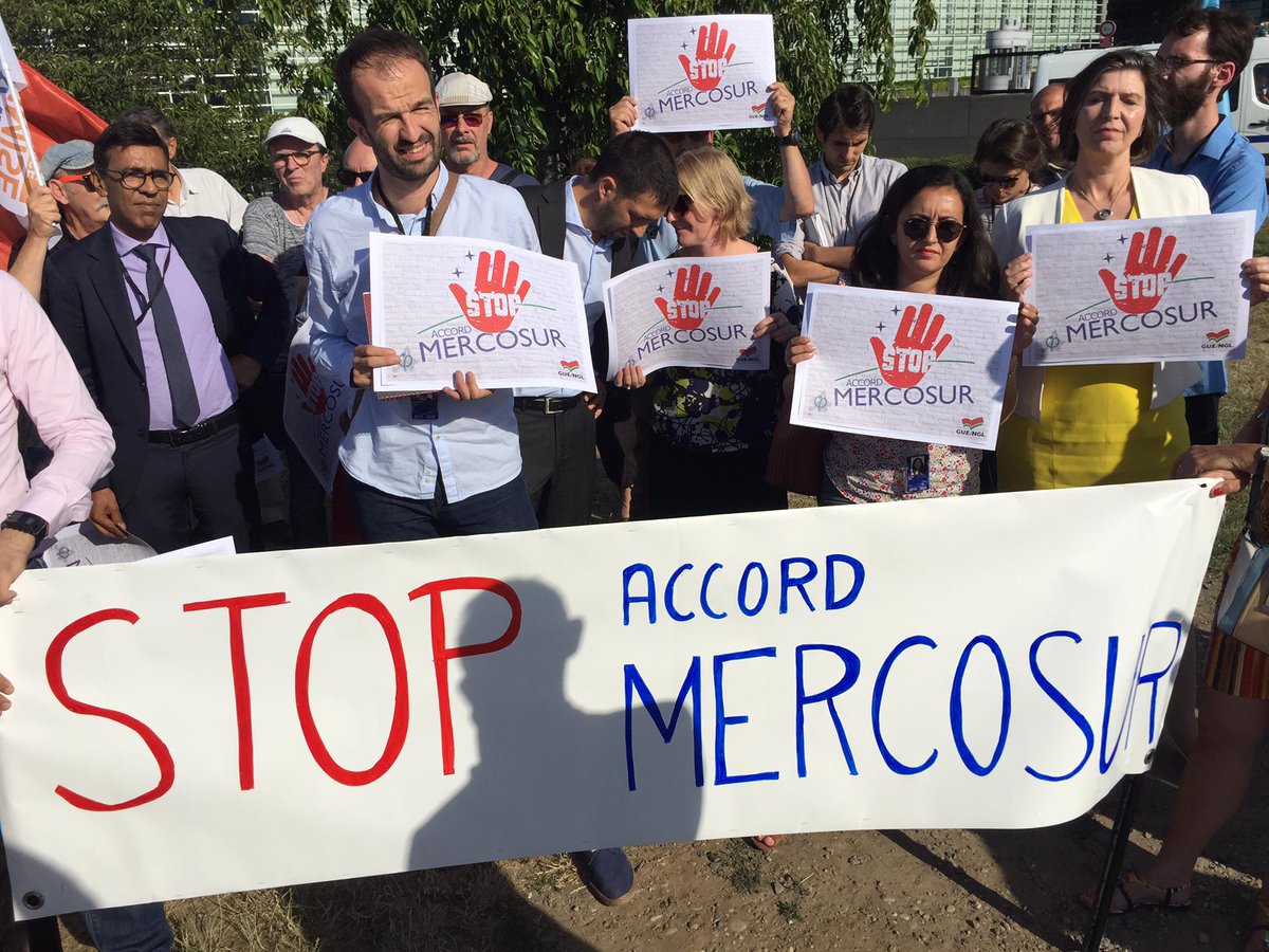 Left_EU's tweet photo. MEPs join protest outside the European Parliament denouncing the conclusion of the EU free trade agreement with Mercosur countries. 

We say a firm NO to the destruction of the environment, to GMOs and the legitimation of Bolsonaro´s far right government. 

#EUMercosur #EPlenary https://t.co/kvyLhYKXwV