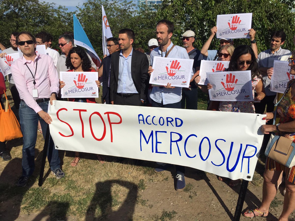 Left_EU's tweet photo. MEPs join protest outside the European Parliament denouncing the conclusion of the EU free trade agreement with Mercosur countries. 

We say a firm NO to the destruction of the environment, to GMOs and the legitimation of Bolsonaro´s far right government. 

#EUMercosur #EPlenary https://t.co/kvyLhYKXwV
