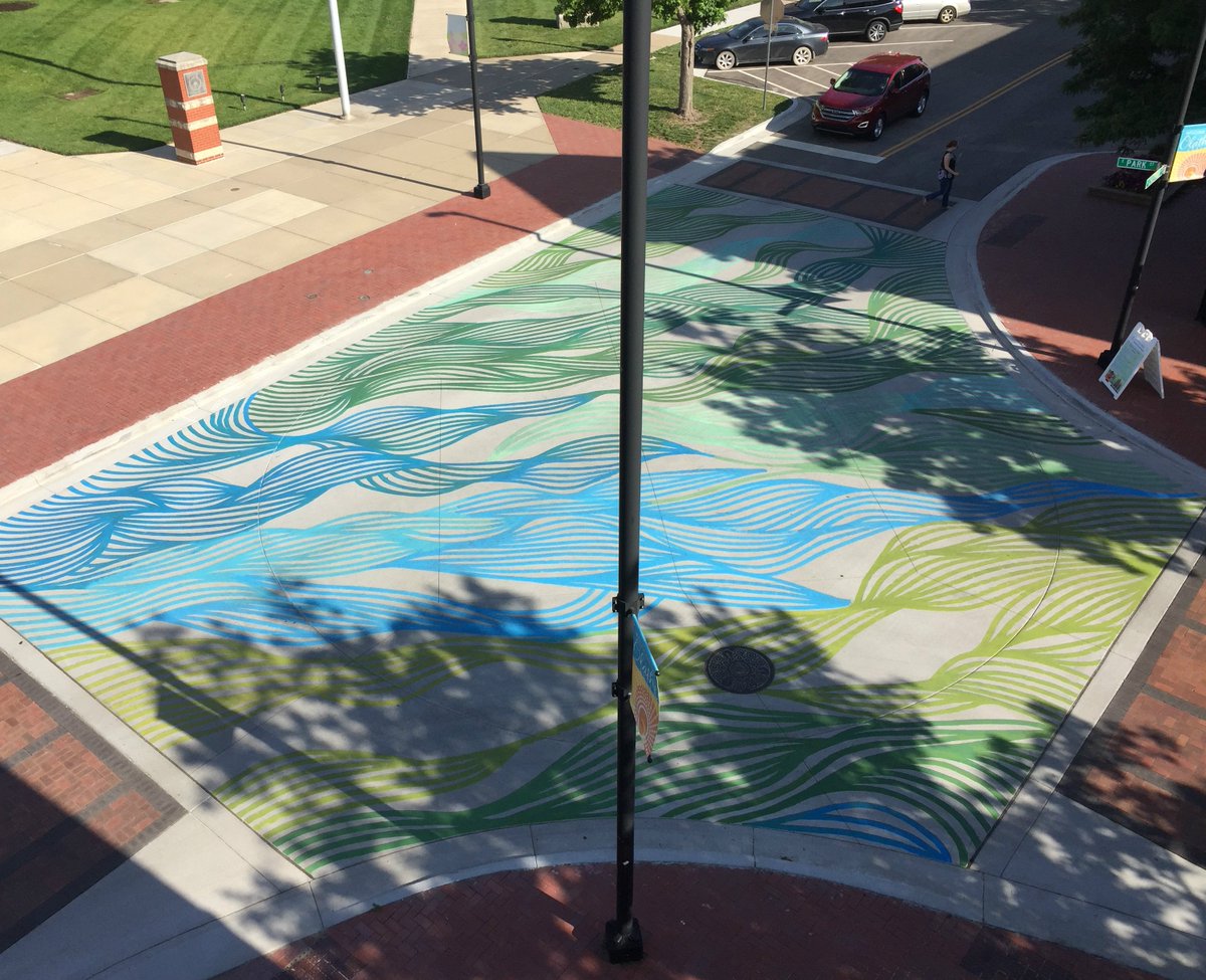 Artist Shogo Yamazaki (<a href="/jayshogo/">Jay Shogo</a>) created a pavement mural in downtown <a href="/CityofOlatheKS/">City of Olathe, Kansas</a> this past weekend. It was designed to increase residents’ exposure to public art. Bird’s eye view of the mural at the intersection of Cherry and Park streets courtesy of @LndWorksStudio.