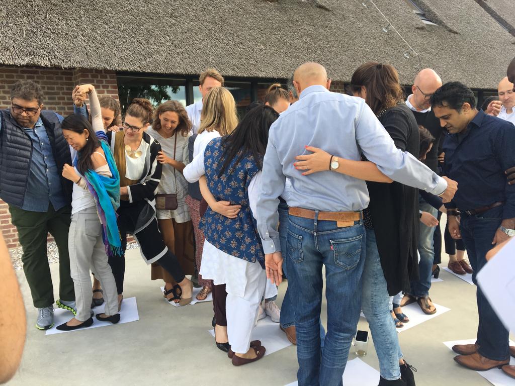 Ashoka's tweet photo. #CAlab participants try to flip pieces of paper while standing on them. Not only are ingenuity and teamwork invaluable skills for leading entrepreneurs, but this activity is also a reminder of the importance of having fun! @PhilipsFDN #AshokaFellows #AHAFellows https://t.co/KyOszEc7fg