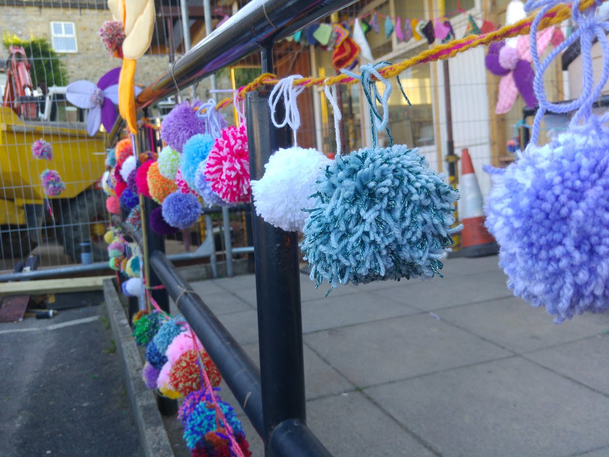trawdenshop's tweet photo. The front of the shop looks like a building site (it is.. great improvements are happening!) so our lovely volunteers have been pom pom making and #yarnbombing ready for Trawden Garden Festival this weekend 🌸🌺🌹 https://t.co/UBW3Ra7InR