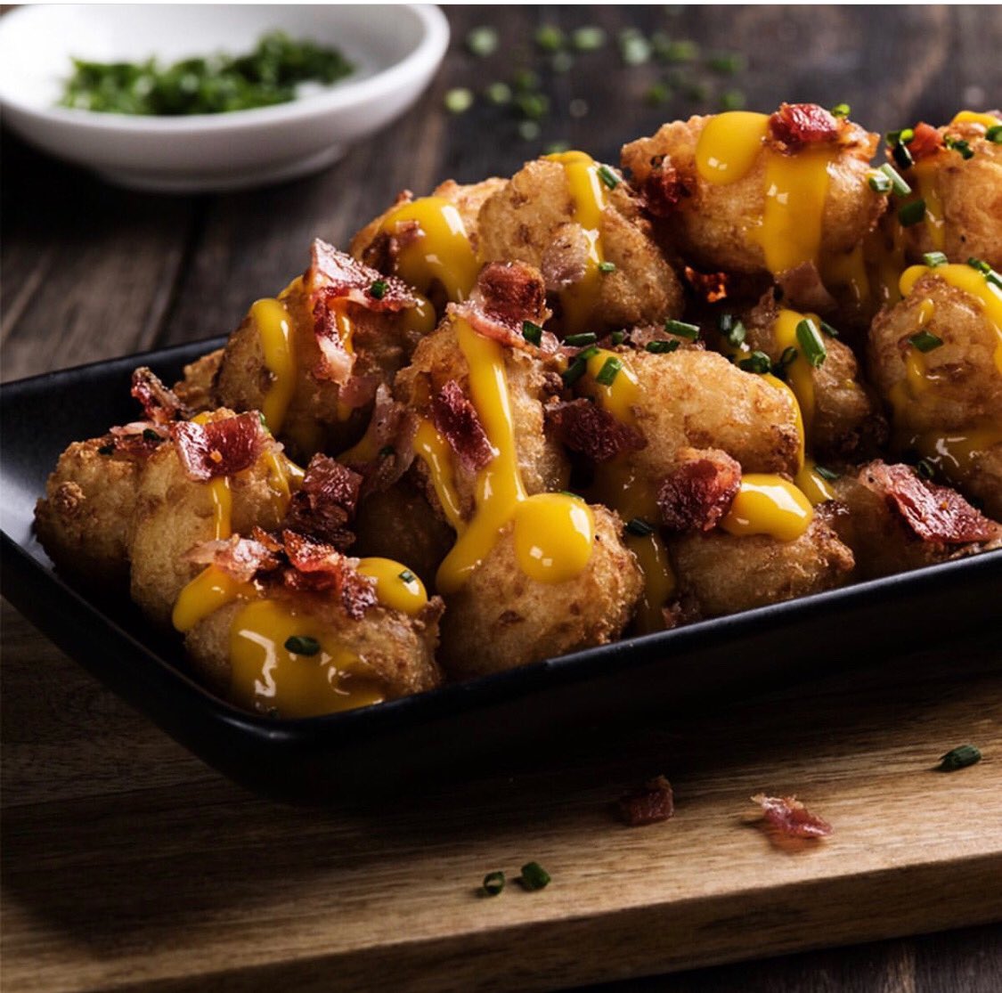 Bolas de patata con queso derretido bañando toda la ración     y trocitos de beicon. ¿Quién puede resistirse? Tommy Mel’s de ⁦<a href="/CCIslazul/">Islazul</a>⁩ #comerbien #food