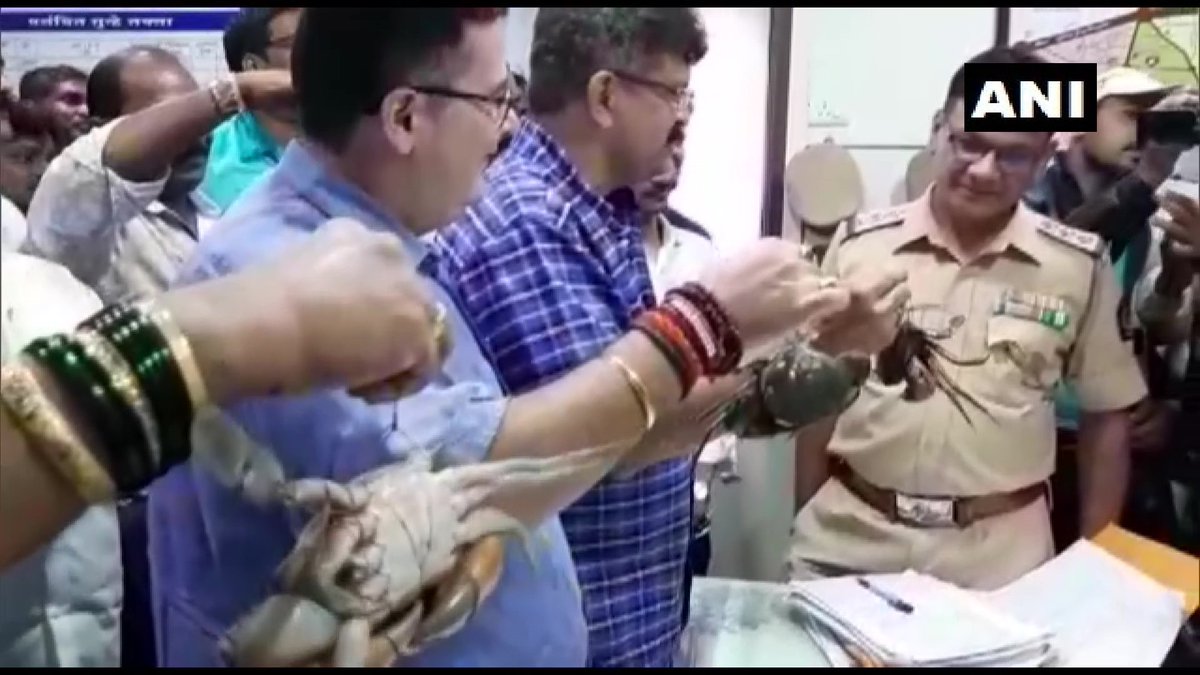 ANI's tweet photo. Thane: NCP's Jitendra Awhad reached police station carrying crabs today as a mark of protest against Maharashtra Minister T Sawant's remark that #Tiware dam was breached because of crabs. Awhad says, "no arrests made yet. Since crabs are responsible for this, I brought them here" https://t.co/ErwpxyE9OK