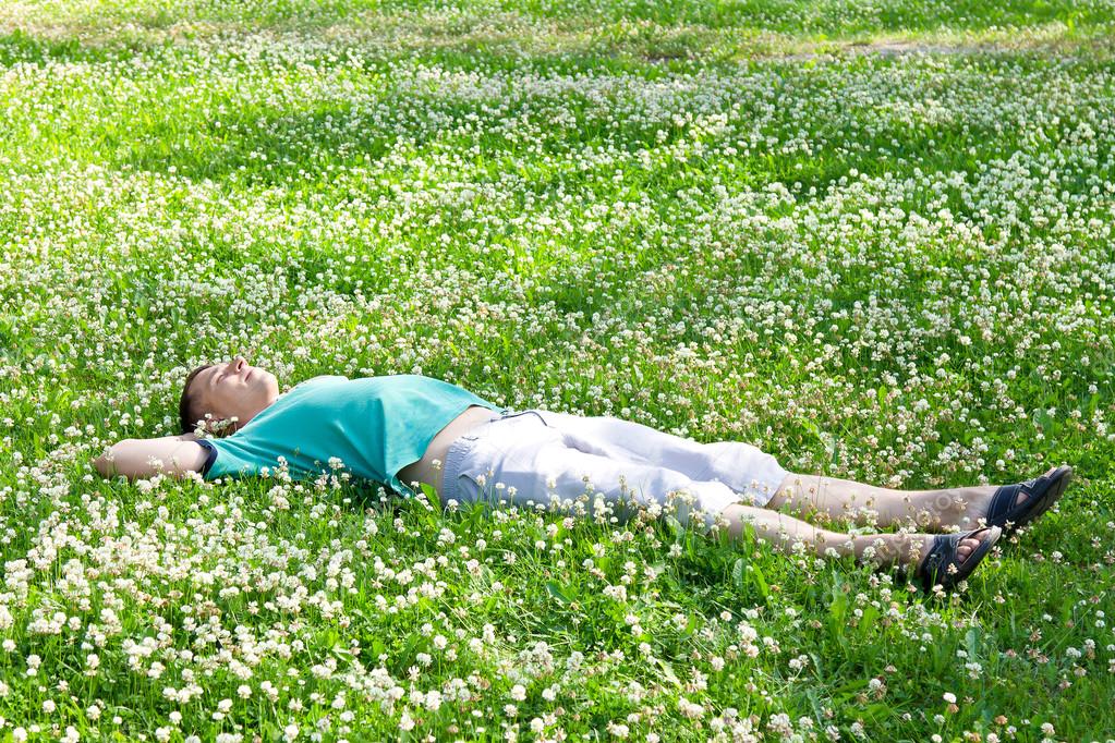 девушка в траве. плед для пикника. девушка лежит в цветах. девушка лежит на траве. лежал на поляне.