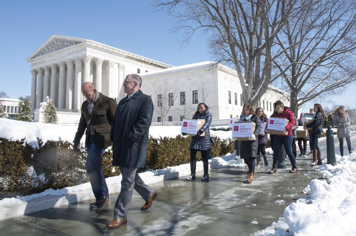 People walking with "The People's Brief" boxes