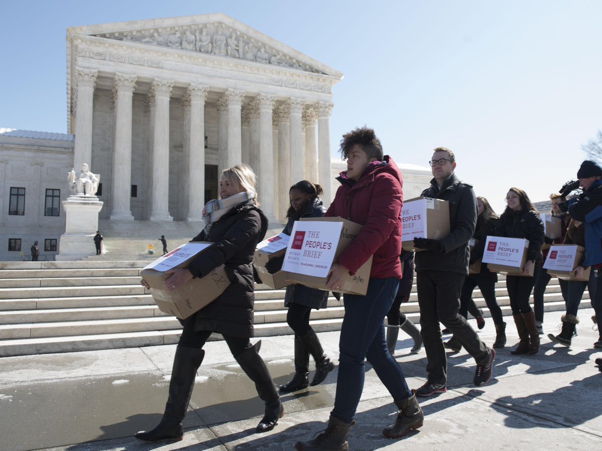 People carrying the "People's Brief" documents in boxes