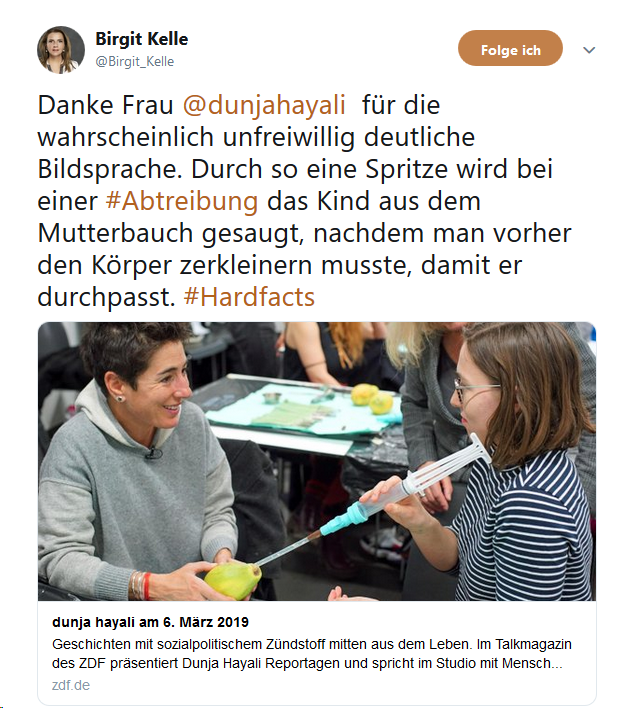 dushanwegner's tweet photo. Staatsfunk zeigt Foto von Haltungsjournalistin, wie sie sich fröhlich lachend (so sieht es aus) Zerkleinerung und Absaugung von Babies erklären lässt. Es wird ihr vorgehalten. Sie »verteidigt« sich und postet Foto, wie sie grimmig das Symbol einer Gebärmutter anstiert. #surreal https://t.co/ZlBTK7Bkij