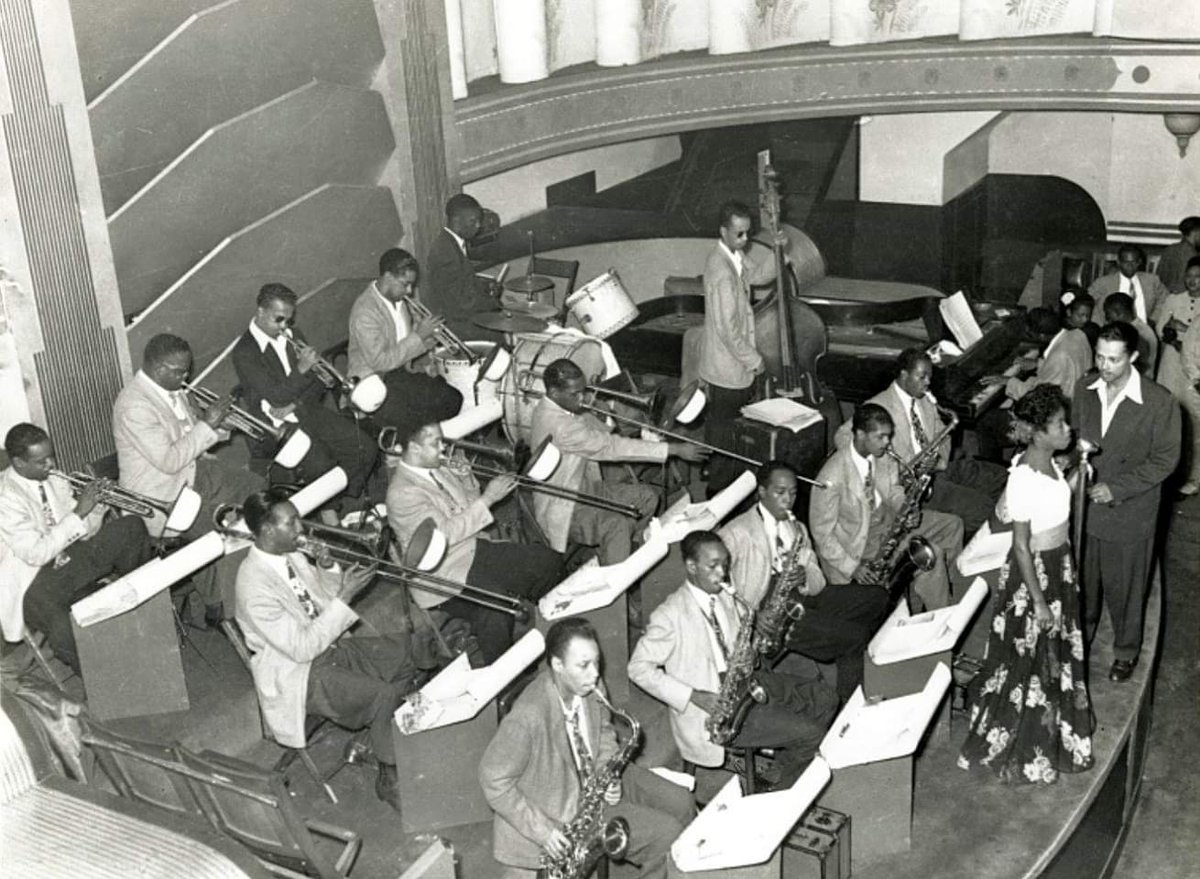 OddPittsburgh's tweet image. Billy Eckstine conducting his band at the Aragon Ballroom (628 Penn Ave) in #Pittsburgh. Charlie Parker on sax (3rd from the left) joins Art Blakey on drums &amp;amp; Tommy Potter on bass. A young Dizzy Gillespie &amp;amp; Howard McGhee are on trumpets in the back row. Sarah Vaughan at the mic.