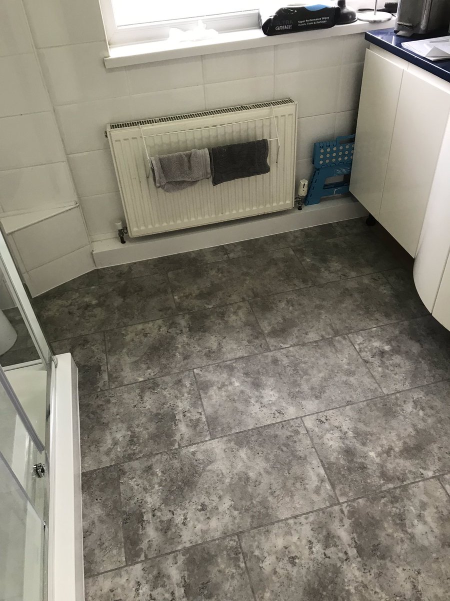 Bathroom works undertaken to replace the damaged walls and floors. White multi panel boards installed and new flooring laid.