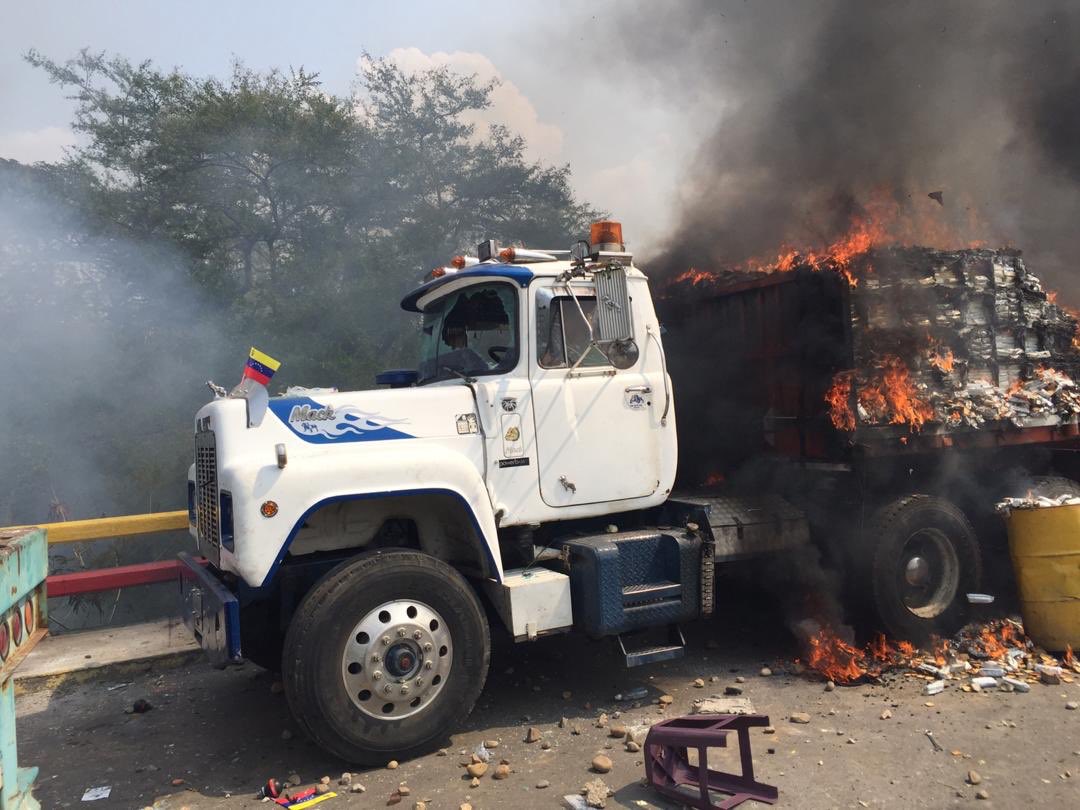 ArnaldoEspinoza's tweet photo. Los camiones de ayuda humanitaria, quemados por el régimen de Nicolás Maduro al cruzar a Venezuela. La gente trató de recoger lo que se podía, gritaba a los GNB si ellos no pasaban hambre.
La indolencia. La maldad. 
Fotos de @luisgonzaloprz https://t.co/MMA80g44kz