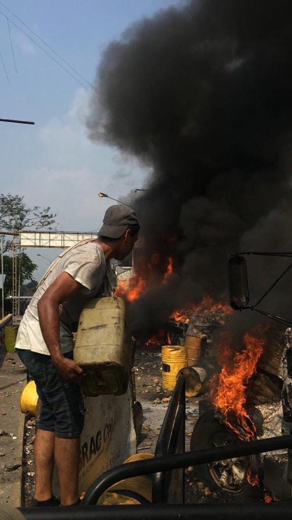 JHostosiana's tweet photo. 🚨🚨URGENTE🚨🚨

Aquí se evidencia que el camión de "ayuda humanitaria" fue quemado en sectores *del lado de Colombia*. 

Miren la imagen; un adolescente con un tanque de gasolina y al fondo, del otro lado de la frontera, se ve la Guardia Nacional Bolivariana (GNB)

Compartir. https://t.co/YWfasQLpUR