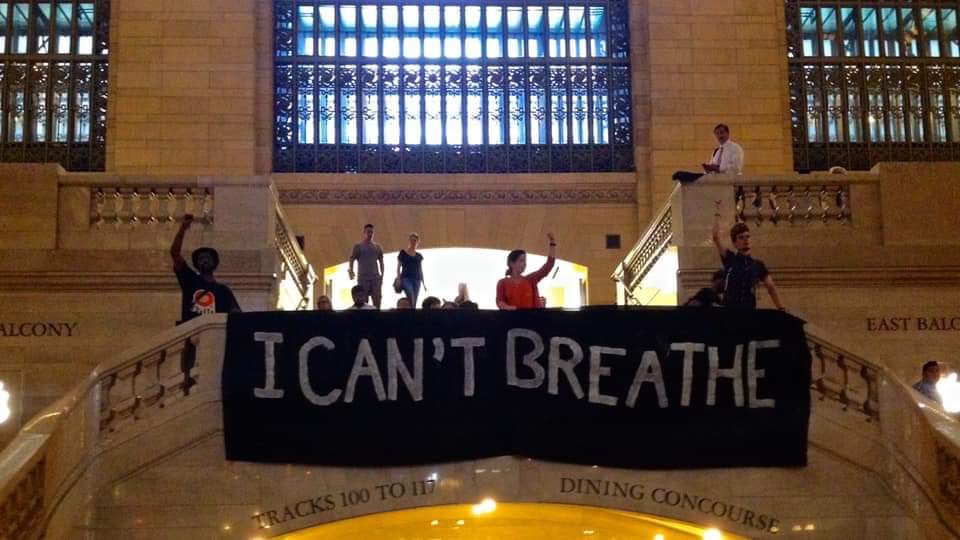 A group of people holding a banner at Grand Central Terminal that reads “I can’t breathe”.