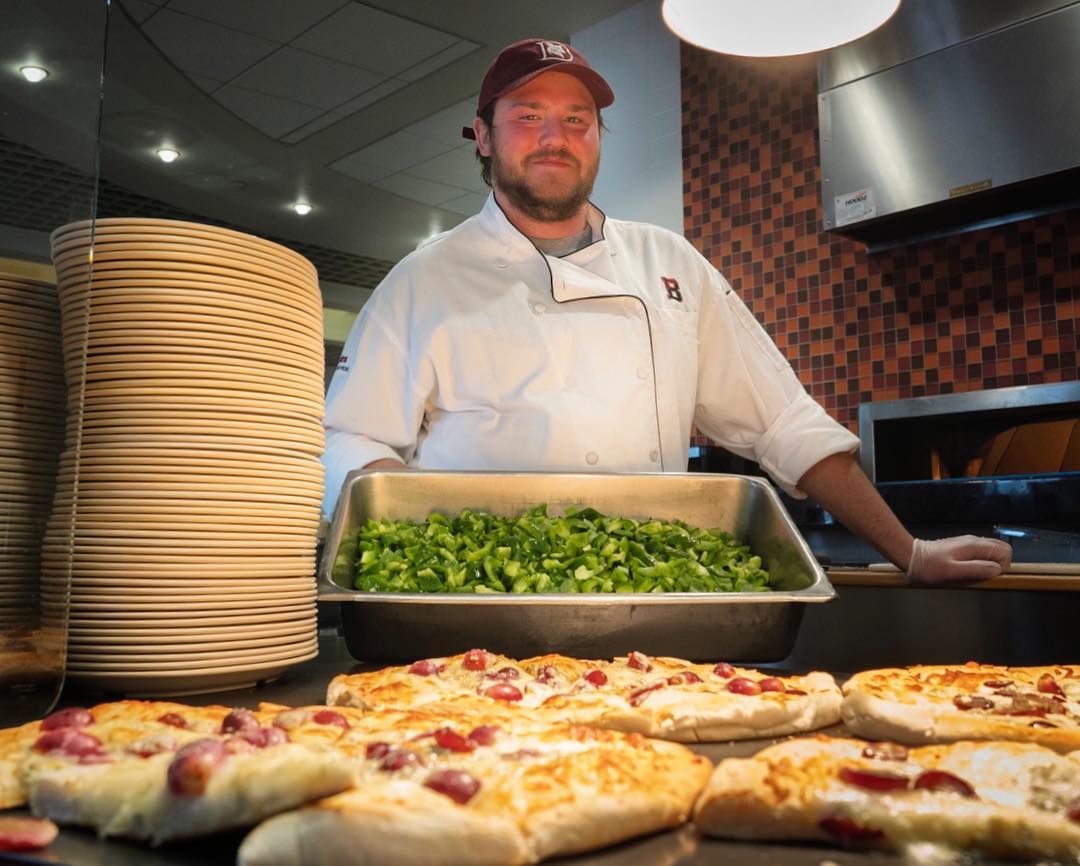 BatesCollege's tweet photo. "I don't like it being slow. It's more exciting when it's busy."
β Dining Services Cook Jacob Morse at the brick oven, where he prepared and served grape and Gorgonzola pizza. He's looking forward to students returning from break. So are we. #beingsofbates (π·: @PGraberJensen) https://t.co/WzmzboDHaK