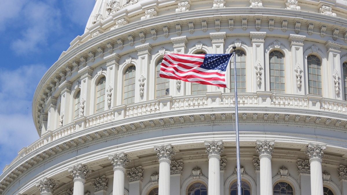 US National Capitol building in Washington, DC with American flag flying.