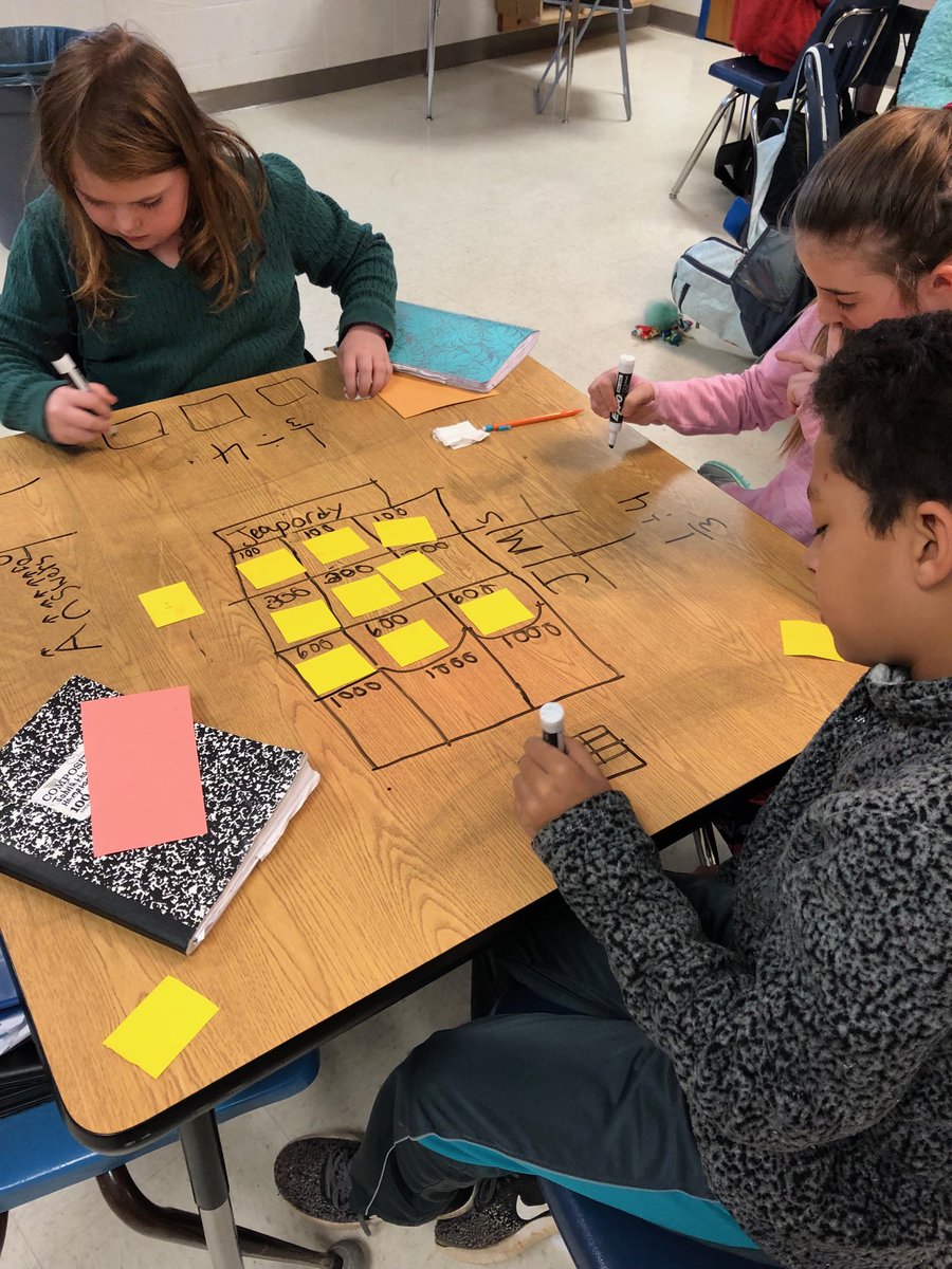 Young mathematicians creating their own dividing fractions game.