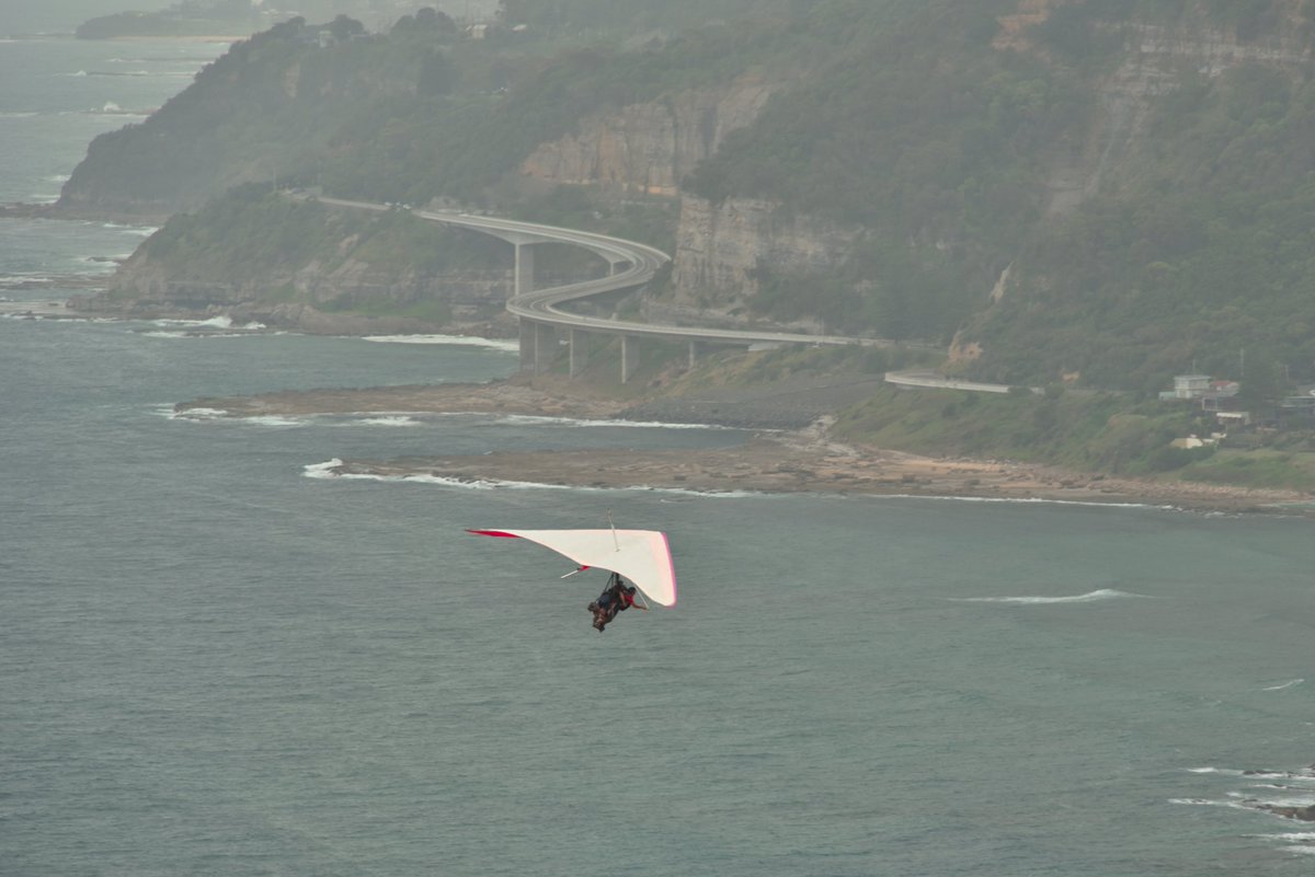 #scape366.com 060 - The brilliant #white #wing of a #tandem #hangglider, contrasting brightly against the #seacliffbridge on an #overcast day. The #flight departing and spotted, from the #baldhilllookout at #stanwelltops #coastscape