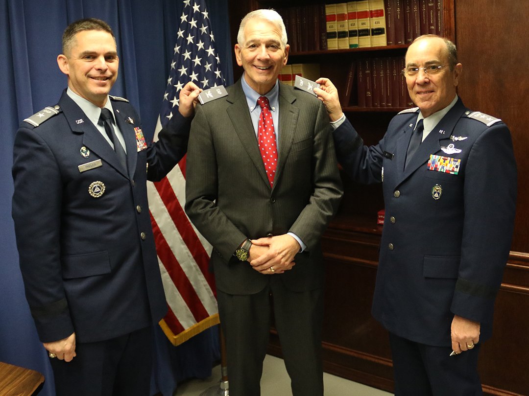 Brig. Gen. Ed Phelka (left), Civil Air Patrol national vice commander, and Maj. Gen. Mark Smith, national commander and CEO, hold the colonel’s shoulder boards signifying U.S. Rep. Ralph Abraham’s new rank as commander of CAP’s Congressional Squadron. Photo by John Swain, CAP National Headquarters