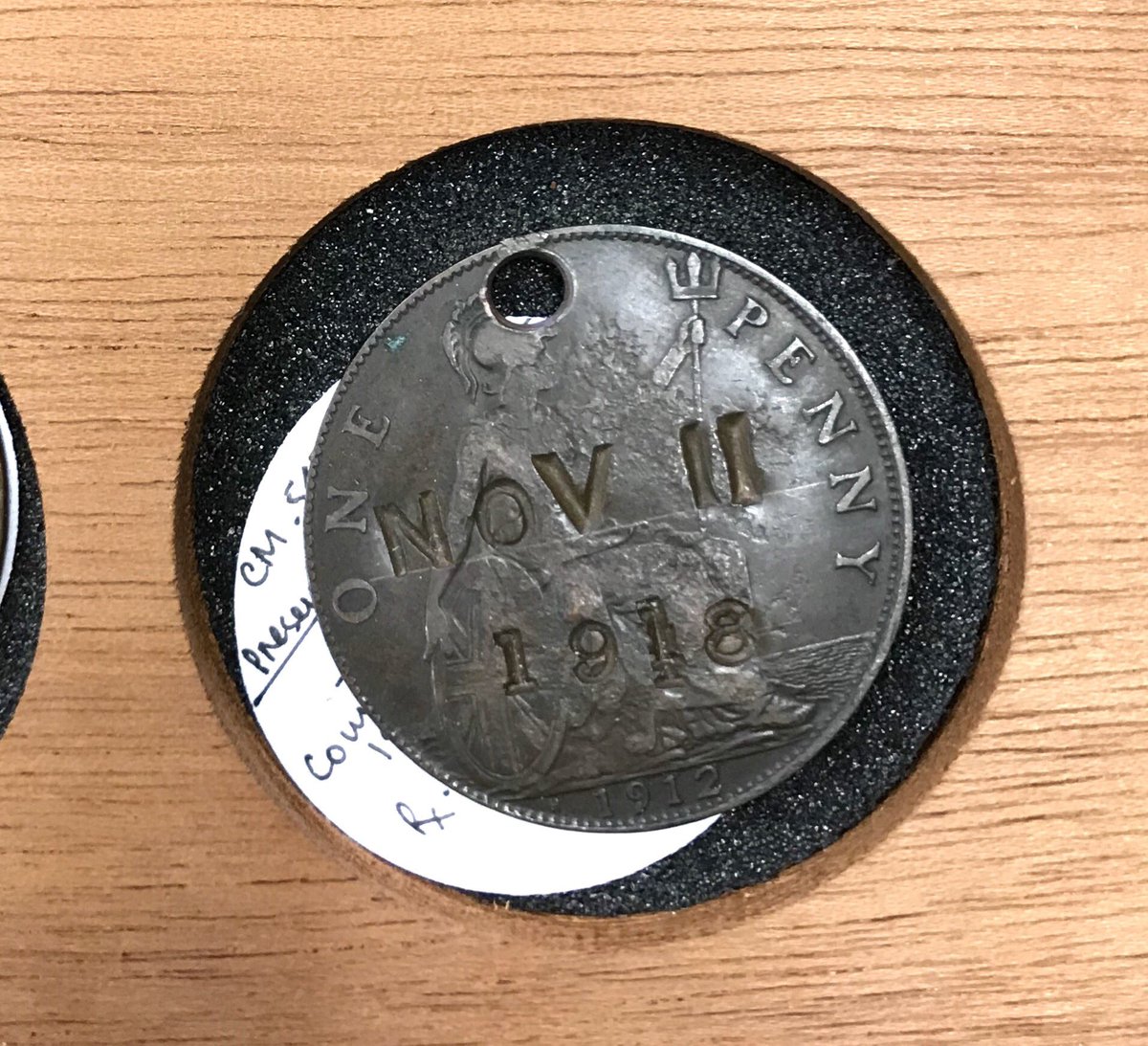 A 1912 English penny countermarked for Armistice Day “NOV 11 1918”, and perforated for suspension, probably to be worn.