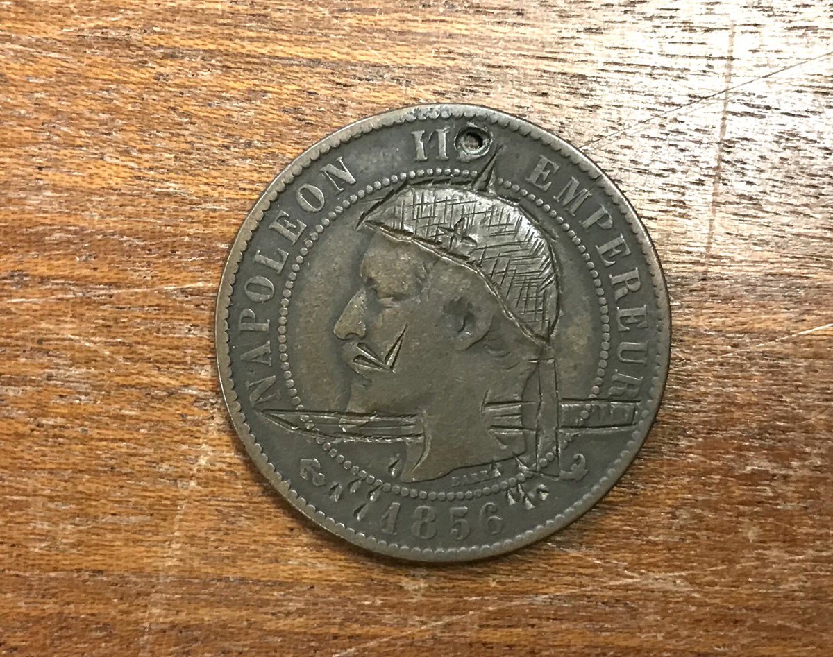 Countermarked Napoleon III coin providing the Emperor with a Prussian helmet, and a dagger through the neck.