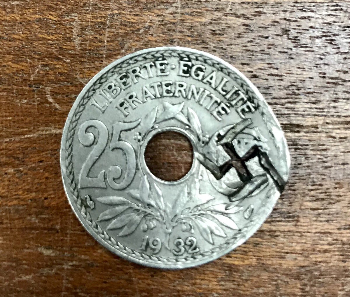 I found this one a particularly troubling object—a 1932 twenty-five centimes, countermarked with a swastika.