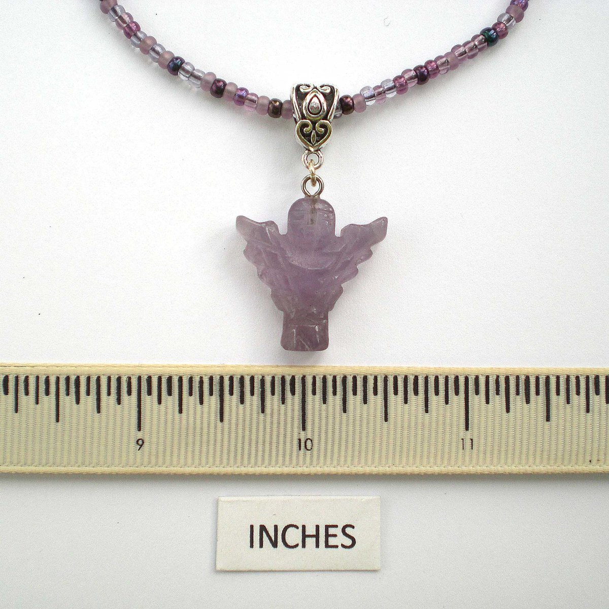 This carved amethyst angel pendant hangs from a chain of purple and mauve glass seed beads. #amethystjewellery #amethystjewelry #angelpendant #angelnecklace #purplenecklace  #purplependant #etsyfinds #etsyjewelry #etsyjewellery #etsyuk etsy.com/uk/listing/586…