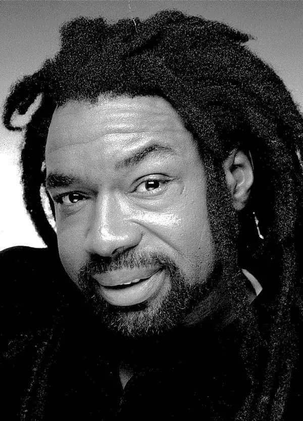 A photo of a Black man, smiling, looking into the camera.