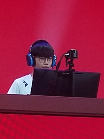 close up photo of sansam peeking over his monitor at the camera