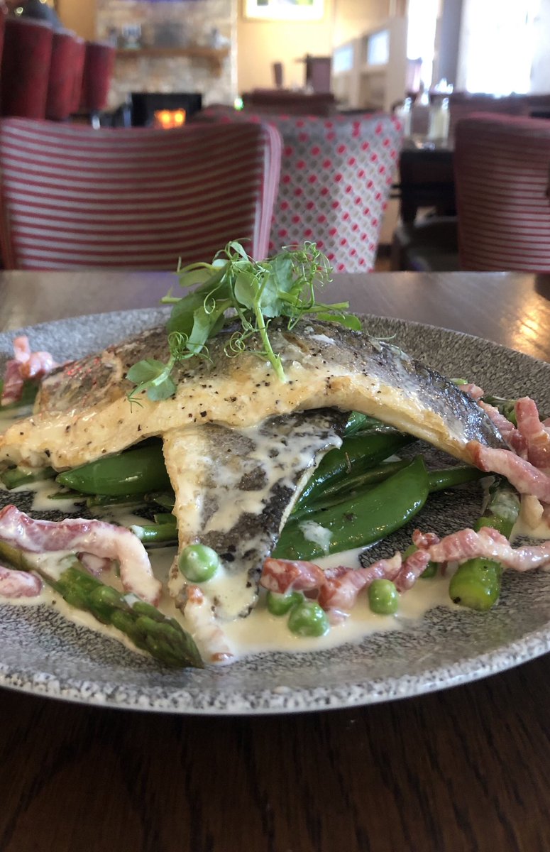 Sea bass on a bed of wilted greens served with a pancetta and pea cream #newmenu #yummy