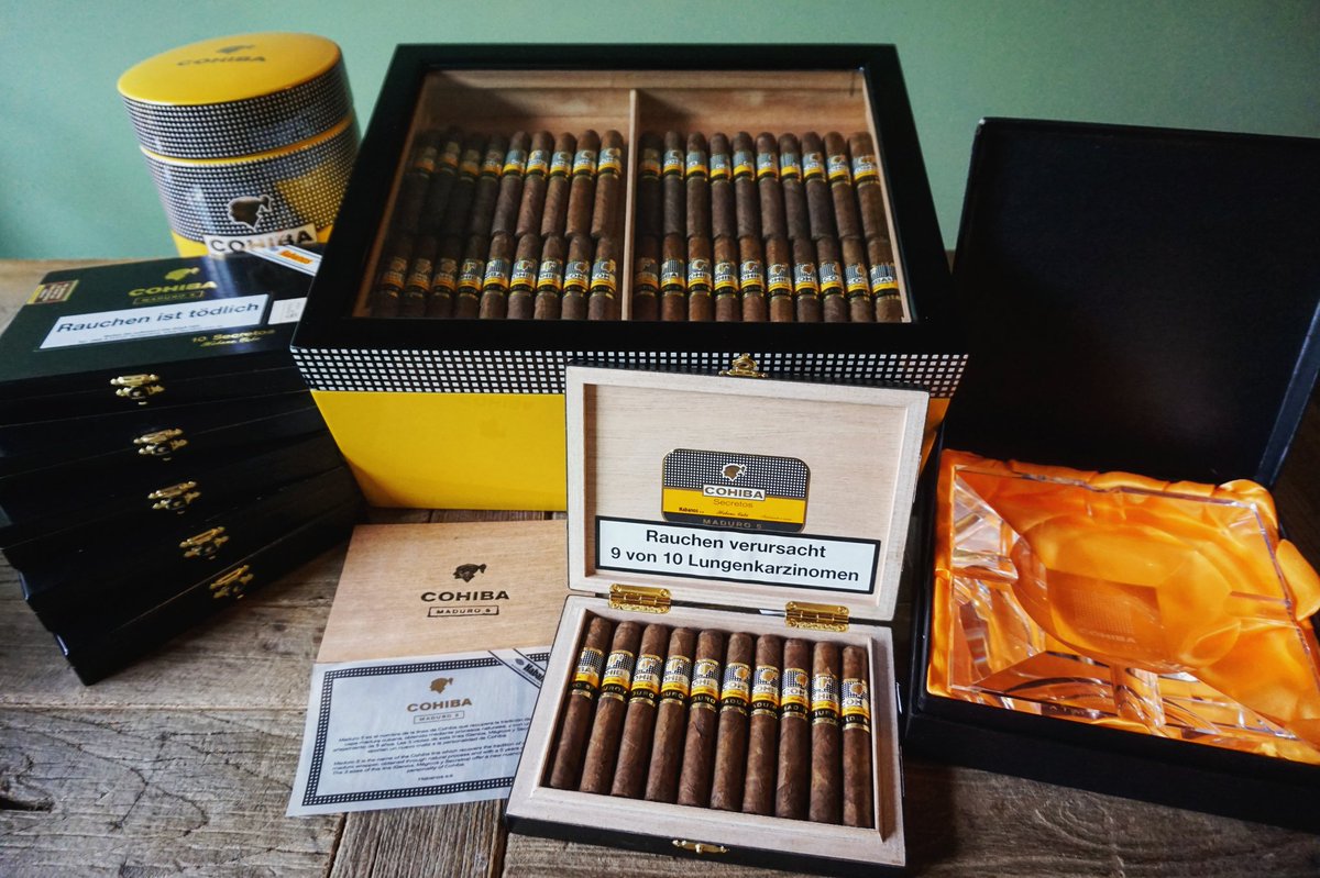 Cohiba Maduro 5 Secretos. Die erlesene Petit Corona zählt zu den seltenen Maduro Smokes aus Kuba. Prägnante Würznoten und komplexe Nuss-, Kaffee- sowie Holzaromen bestimmen ihren kräftigen Geschmack, der jeden Aficionado ins Schwärmen versetzt. noblego.de/cohiba-maduro-…