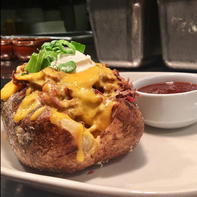 jackstackbbq's tweet photo. Looking for lunch? Our Barbecue Stuffed Potato comes with your choice of pulled pork, chopped burnt ends, or smoked turkey. Then we top it with cheddar cheese, sour cream, butter, &amp; green onions. You can’t beat that! #KCBBQ #JackStackBarebcue #LunchUpgrade https://t.co/Z1A8joNPdI