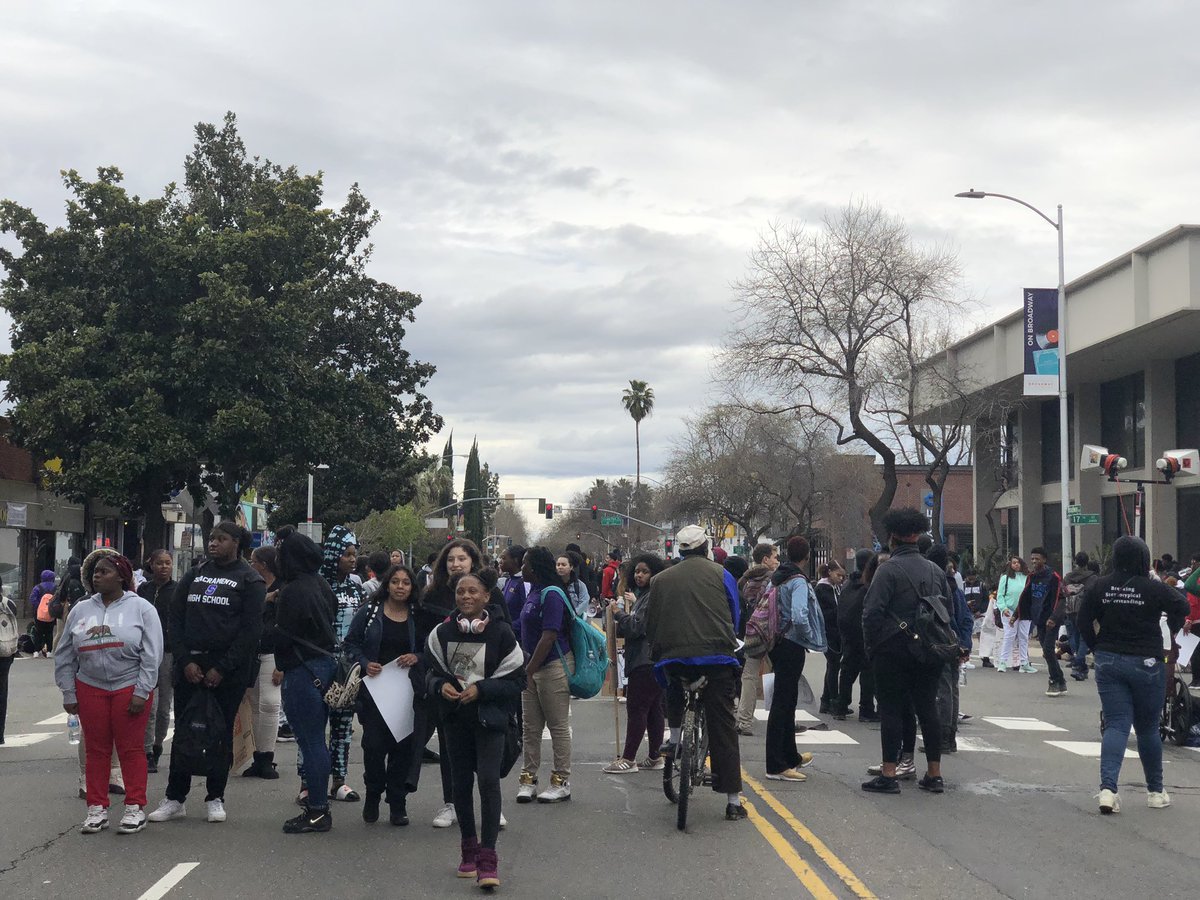 Kasmira_e's tweet photo. Police blocking off major thoroughfare Broadway, as students stop in front of the Queen Sheba restaurant for a brief standstill. Students now marching on towards the Capitol #sacramento @kfbk https://t.co/un5waA2N3v