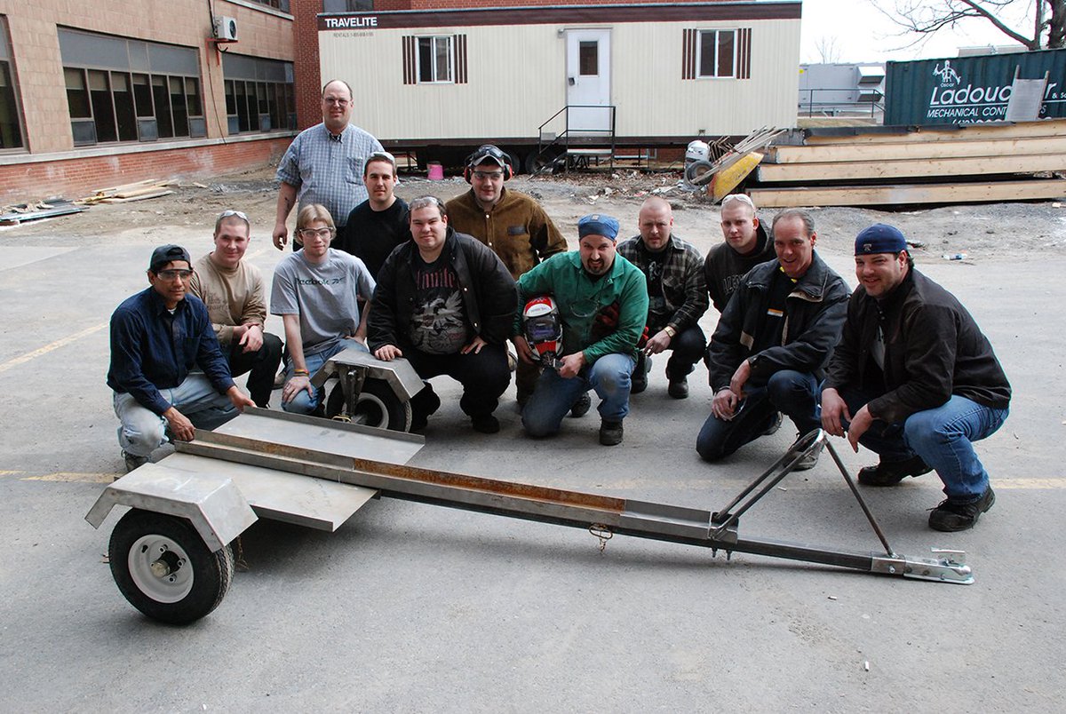 SLC_Alumni's tweet photo. Today's #ThrowbackThursday of the Skilled Trades students and their fabricated trailer at the #Cornwall campus, possibly from the last decade. Can you identify the program and year? #TBT #2000andsomething #ProudtoBeSLC #rememberwhen #SLC_Archives @whatsinsideslc https://t.co/hCp37lGv98