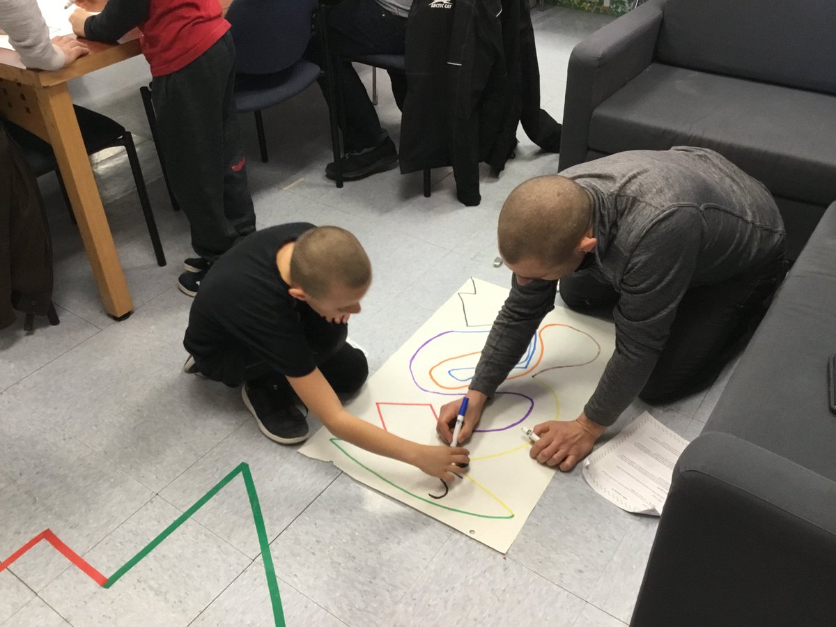 Des enfants et parents engagés à résoudre des défis robotiques.