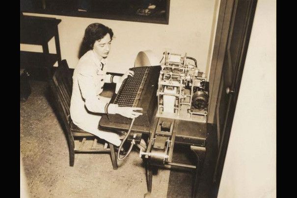 Grace Hopper sits at an early computer