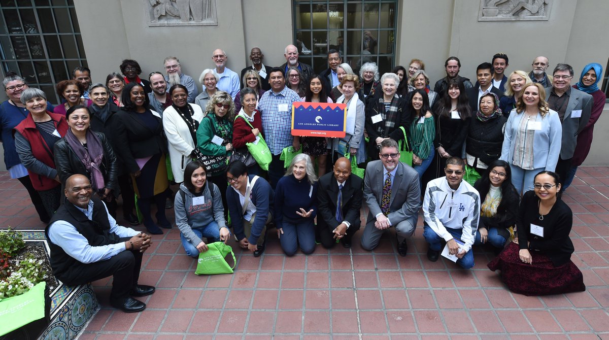 group photo of staff and volunteers holding giant library card