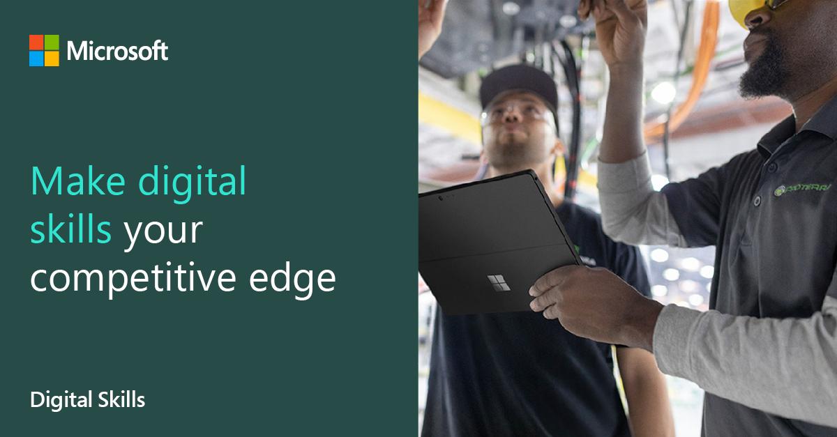 Image of two men under a vehicle with tablet in hand 